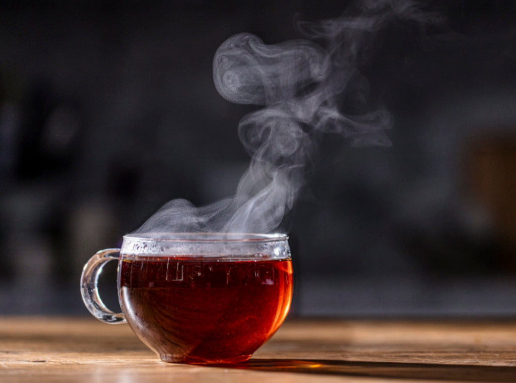 A cup of steaming Mighty Leaf Assam Golden Tip black tea on a tabletop